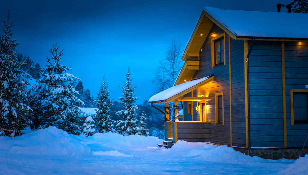 House in Alaska at night with snow and trees